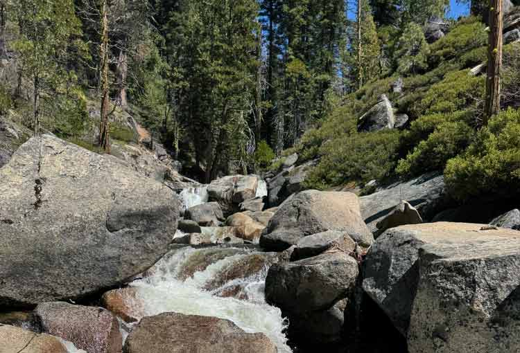 waterfall over rocks with trees in the background